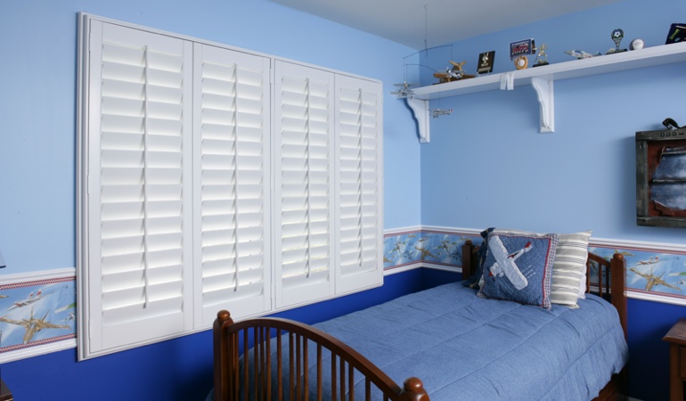 White plantation shutters in blue kids bedroom in Houston 